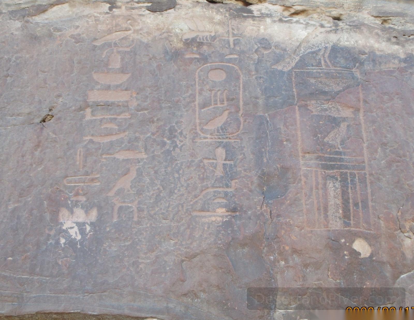 Ancient hieroglyphs carved into a rock face at Wadi Kharig in South Sinai, connected to early mining landscapes.